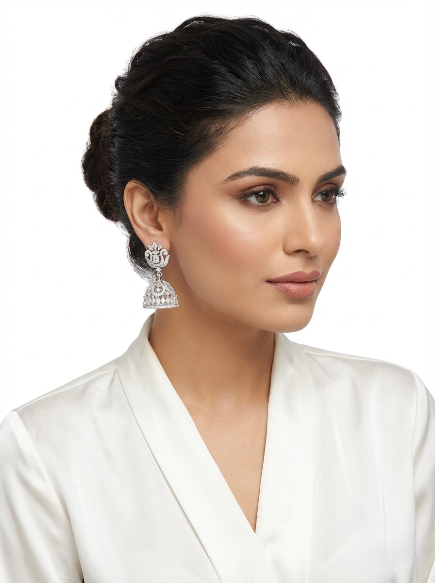 Woman wearing silver jhumka with a white background