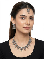  Young woman wearing the Bella heritage silver oxidised bell-fringe choker and tikka for an elite bridal jewellery look.