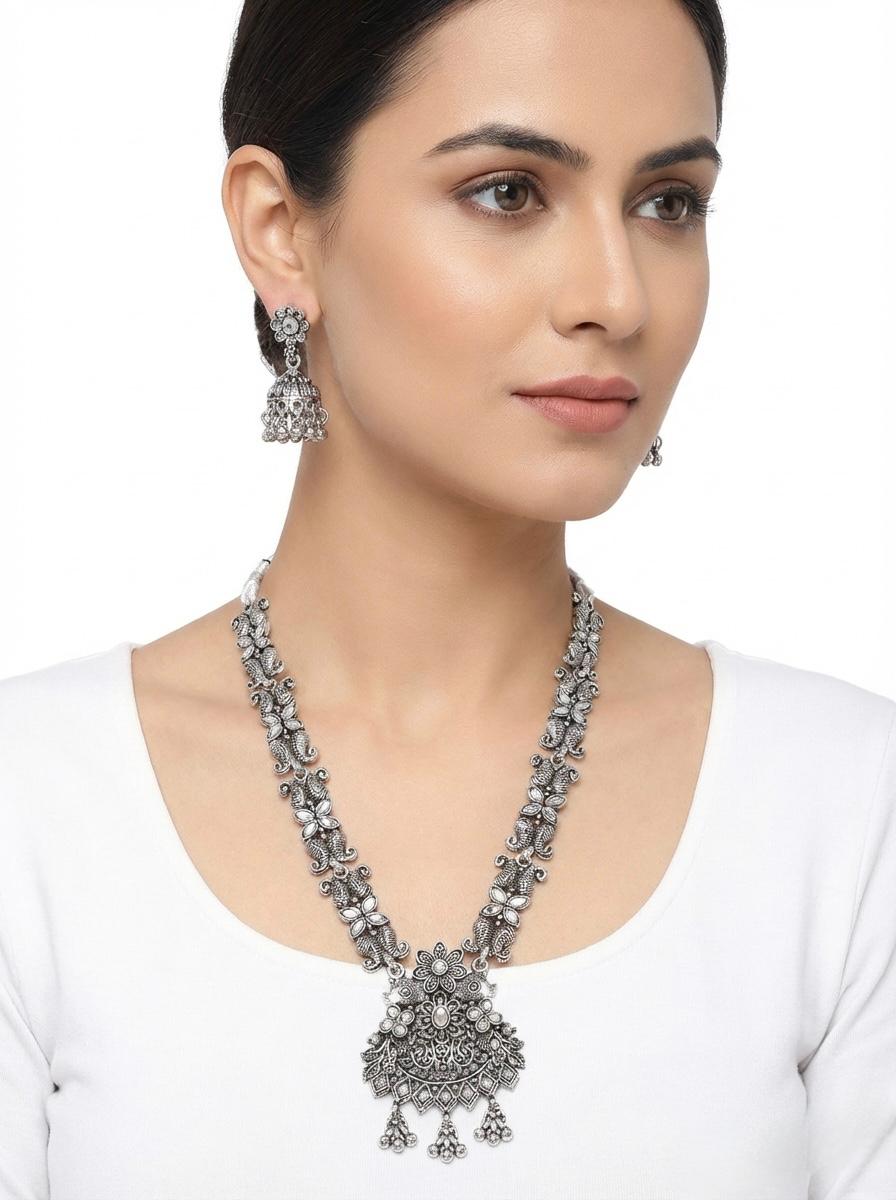 Young woman wearing the Elara high-grade silver oxidised necklace and earring set, styled as posh evening jewellery for a luxury bridal look.