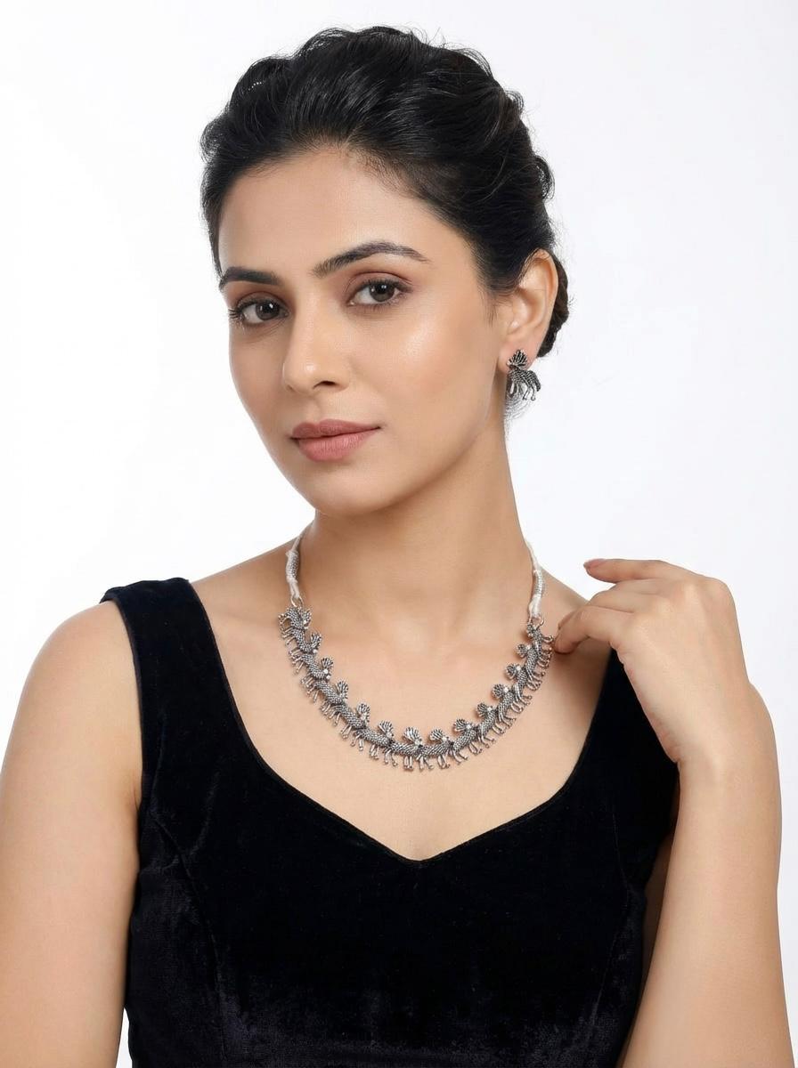  Young woman wearing the silver oxidised deer trail necklace, styled as an elite statement piece for an evening look.
