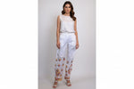 A pair of white stretchable cotton pants with pockets both sides and multi-coloured thread floral embroidery, featuring a relaxed fit with an adjustable drawstring waistband.