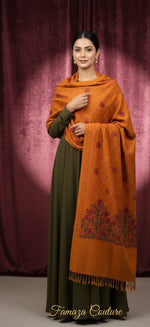 Woman wearing an orange shawl over a green dress against a purple curtain background