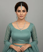 a rhodium-plated brass jewellery set with American diamond and semi-precious turquoise stones, including a necklace, earrings, and maang tikka by Famaza couture 