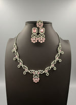 a set of AD (Artificial Diamond) jewellery which includes a necklace, earrings, and a maang tikka with pink centre stones by famaza couture 