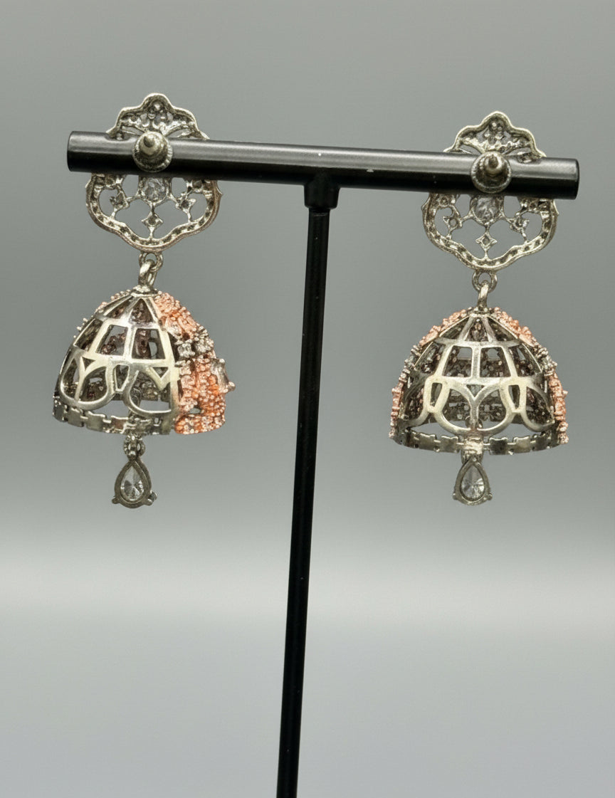 black base metal small earrings with small jhumkey back side design is showing in the image. 