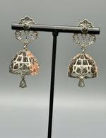 black base metal small earrings with small jhumkey back side design is showing in the image. 