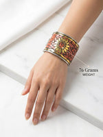 Close-up view of the intricate hand-set coral peach sunburst mosaic stone centerpiece on the artisan heritage cuff