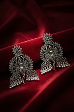 Side profile view of a model wearing handcrafted dancing fairy oxidised silver dangle earrings with ethnic outfit