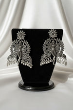 Close-up detail of antique oxidised silver polish on dancing fairy doll silhouette statement earrings