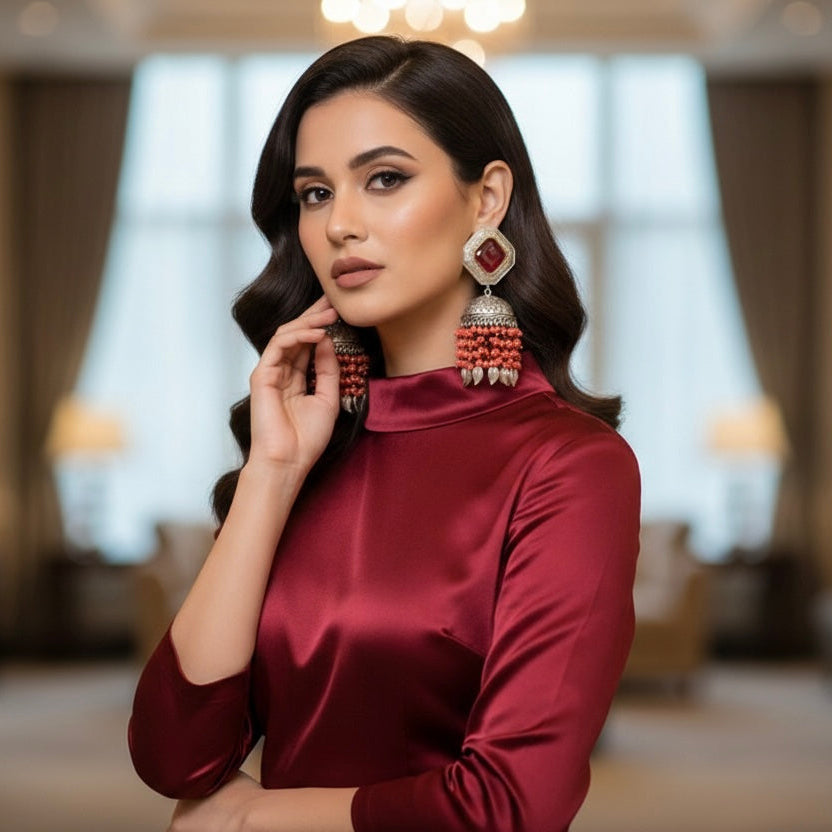 The earrings carries the redstone in the top stud and carrot red hangings underneath the Jhumkey dome and nano oxidised hanging in in the last