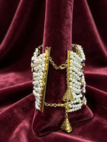 The 25-gram lightweight Empress Jodha Navratna pearl and gold cuff worn elegantly on a bride's wrist.