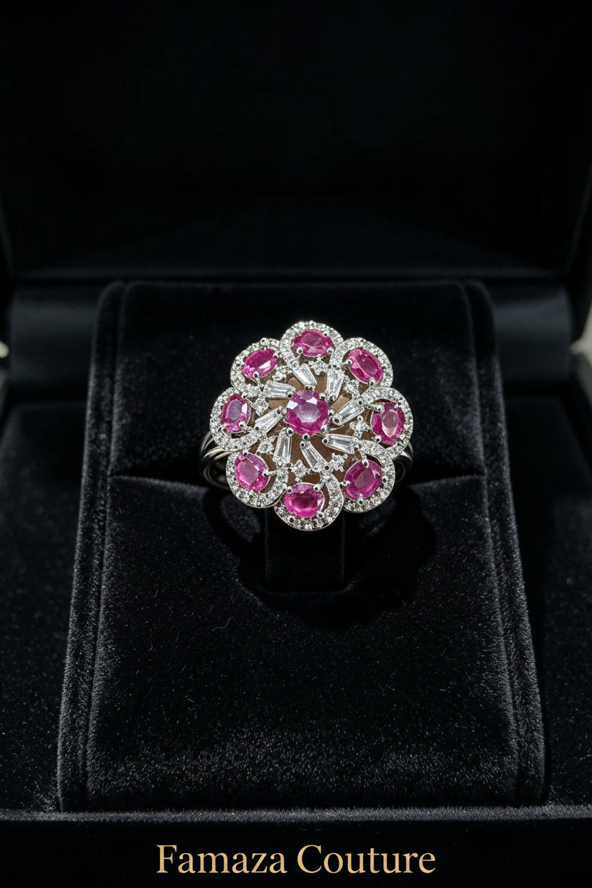 The Famaza Couture Royal Magenta-Pink Floral Cluster Statement Ring displayed inside a luxury black velvet presentation box, highlighting its detailed silver-tone crystal setting and vivid magenta stones.