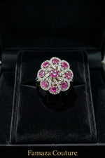 The Famaza Couture Royal Magenta-Pink Floral Cluster Statement Ring displayed inside a luxury black velvet presentation box, highlighting its detailed silver-tone crystal setting and vivid magenta stones.