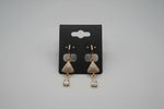 full look from the front view of the Gold triangle-shaped rose gold polished earrings on a stand 