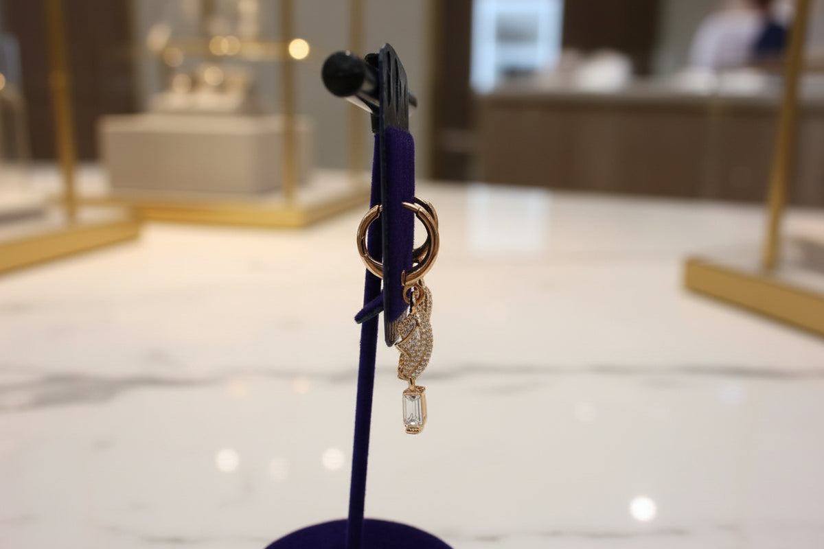 full look from the side view of the Gold triangle-shaped rose gold polished earrings on a stand 