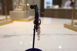full look from the side view of the Gold triangle-shaped rose gold polished earrings on a stand 