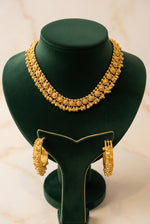 Gilded Grace gold-toned filigree choker and matching bead-trimmed hoop earrings on a green velvet stand