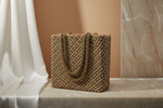 A tote bag with gold diagonal lines and long beads handcrafted on a gold silk base.
