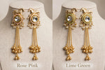Rose Pink and Lime Green Golden Gallop earrings shown side by side on linen display busts, with horse motifs and long chain tassels.