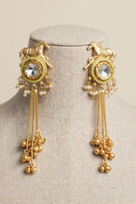 Lime Green Golden Gallop horse motif earrings with reflective kundan centres, pearl-style beads and gold-tone tassels on a linen bust