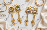 Lime Green and Rose Pink Golden Gallop Meenakari earrings arranged on marble, with horse motifs, pearl-style accents and long tassels.