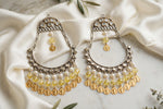 Pair of Kahani chandbali earrings with silver-tone crescent frames, yellow beads and gold-tone coin charms on ivory satin.