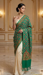 Woman wearing a green and red saree with a white blouse in an elegant room.