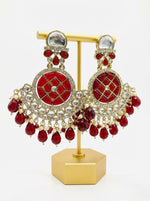 Front view of large maroon Chandbali earrings with crystal halos and hanging red droplets worn by our model.