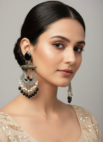 Decorative earrings with black and white details on a textured white surface