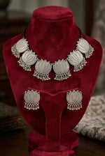 Lotus Whisper oxidised silver-tone lotus necklace and matching earrings on a red velvet display