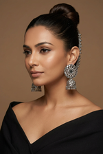 Model wearing silver-toned mirror-work jhumka earrings with floral tops and Sahara ear chains hooked into her bun