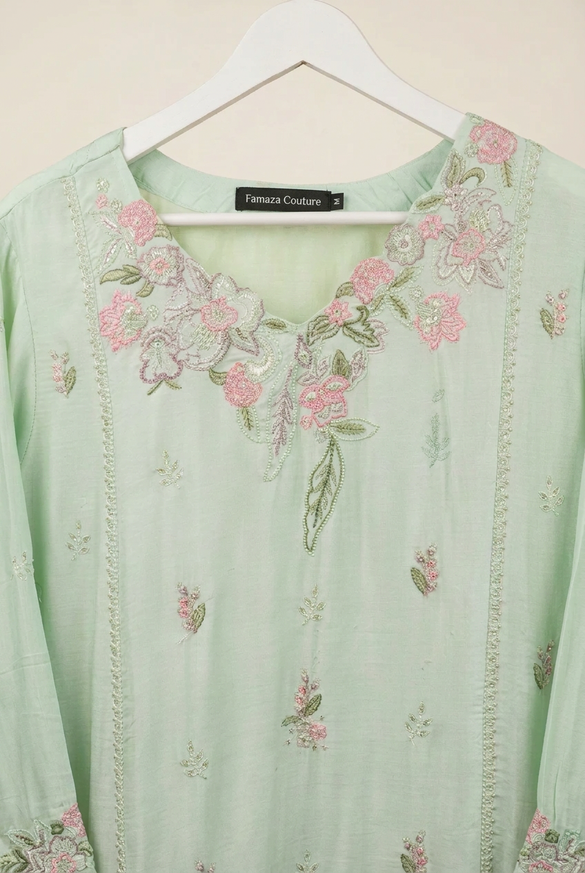 Close-up of pink floral and green leaf embroidery around the neckline of a mint green kurta