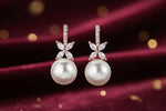 Pearl earrings with floral designs on a black background