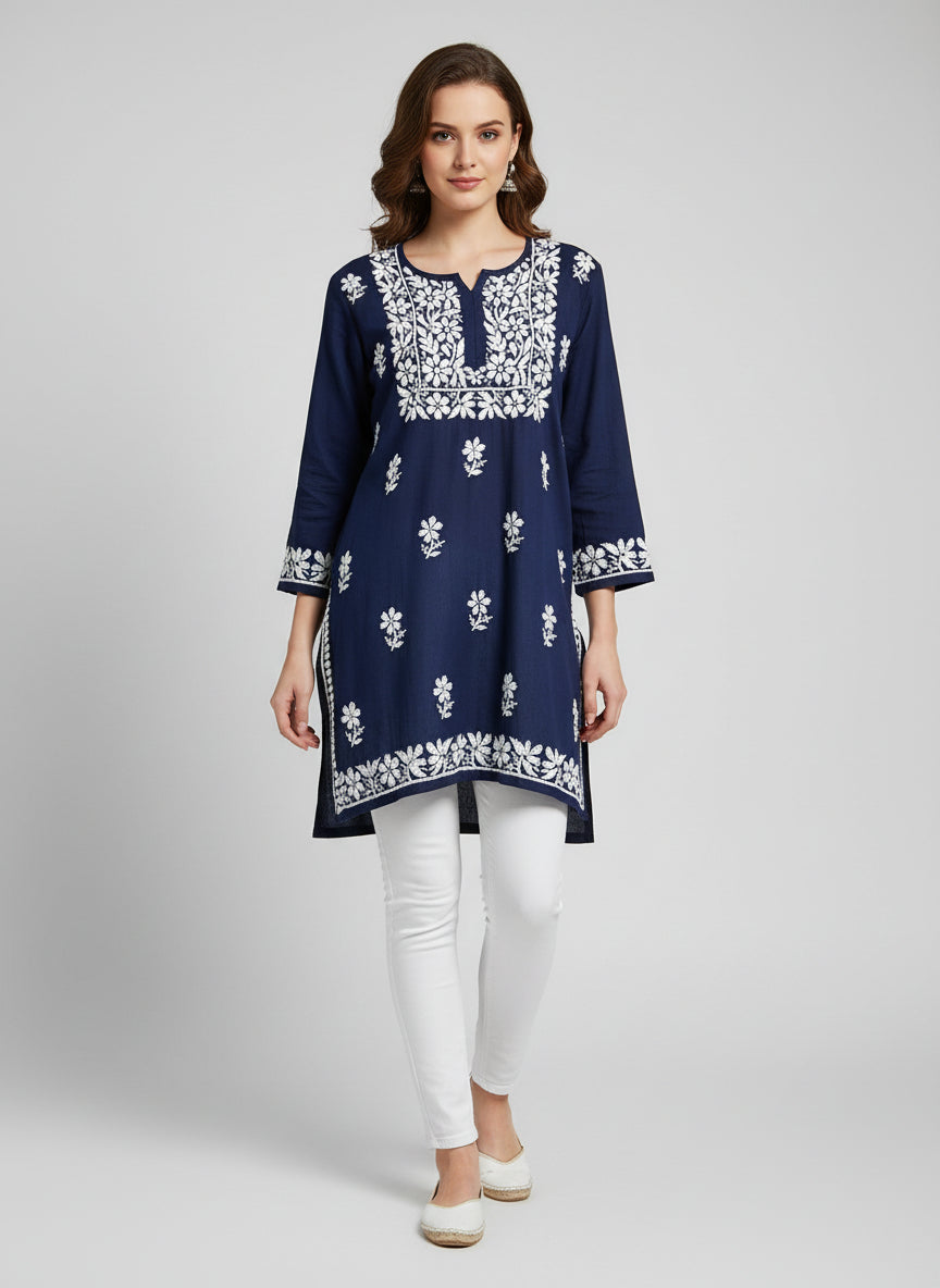 model is wearing and posing in this navy blue colour short length Chikankari kurti with white floral hand embroidery with white jeans