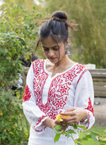 model is wearing the white kurti with red embroidery 