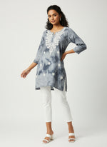 model is wearing this short length grey colour kurti in tie & dye colour with white machine embroidery by famaza couture 