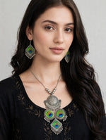 Model wearing the Mor-Mahal oxidised peacock pendant necklace and matching green and blue drop earrings