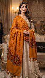 Woman wearing a traditional outfit with an orange shawl in an elegant room.