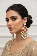 A pair of gold-plated Parul Pearl kundun earrings with intricate designs and drop-shaped pearls, displayed on a stand.