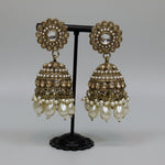 pair of rose gold polish jhumkas with nano pearls ,ad stones and pear drop pearls hanging.