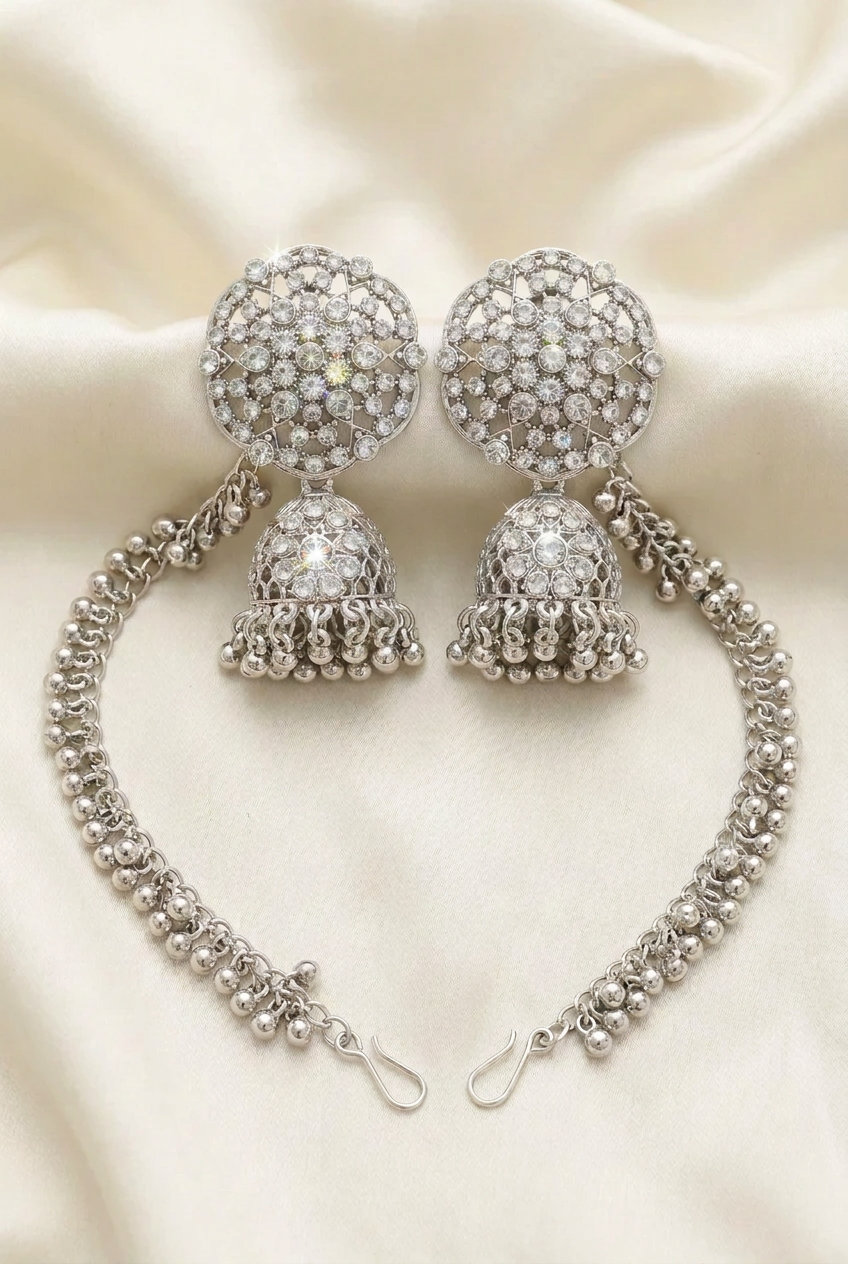 Pakeezah Moonlight jhumka earrings on ivory silk, with Sahara chains laid out and end hooks visible.