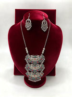 Peacock Radiance oxidised triple pendant necklace with multicolour accents and matching hook earrings on a red velvet stand