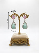 pink and sea green foam colour teardrop earrings on a decorative stand with measurements.