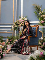 Seated view of Rosalie black floral Dhanak suit showing the floral hem, lace trim and draped paisley shawl.