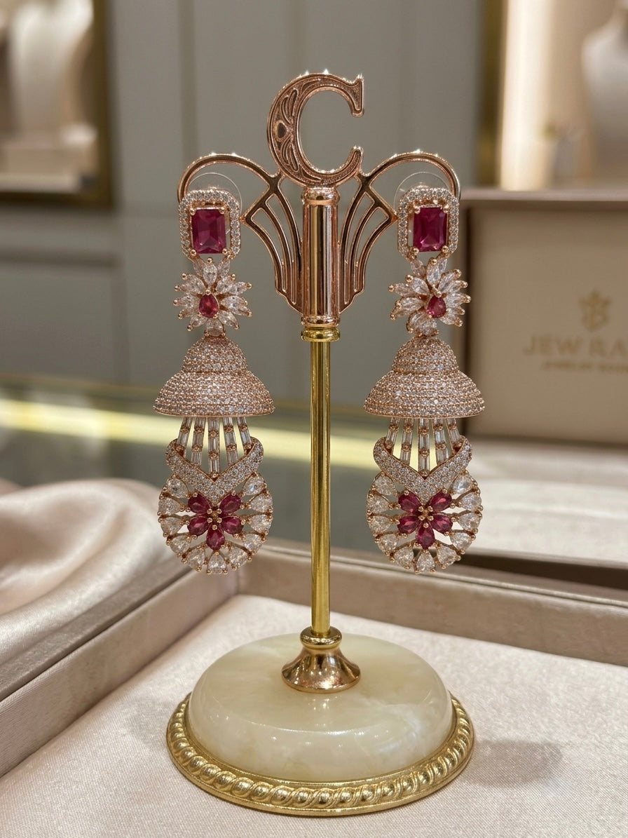 ruby pink American diamond earrings are displayed on a stand. 