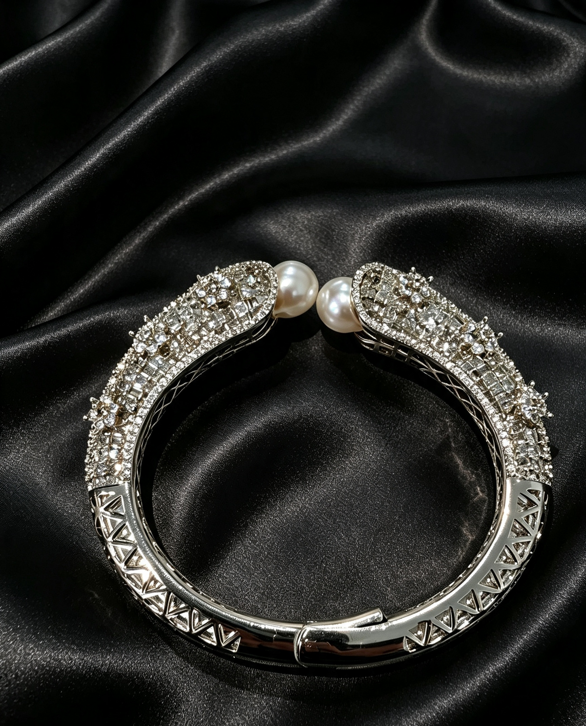 Famaza Couture Silver Crystal & White Pearl Luxury Bangle Bracelet — flat-lay on luxurious black satin, showcasing intricate silverwork, pave-set crystals, and luminous white pearls.