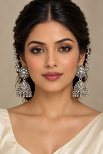 Oxidised silver-tone Bahubali jhumka earrings with mirror-work and Sahara chains worn by a model.
