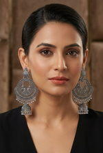 Model wearing Silver Serenade silver-tone elephant motif chandbali jhumka earrings with floral tops