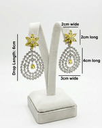  silver earrings on a white stand with measurements indicated.