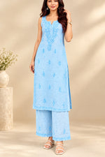 A woman wearing a light blue embroidered kurta set with matching wide-leg pants.